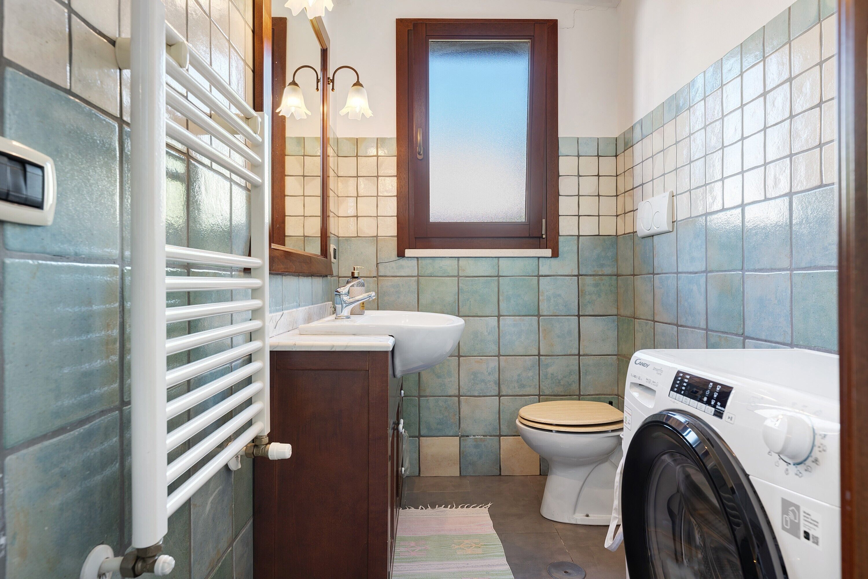 Un baño pequeño con inodoro, lavamanos y lavadora.