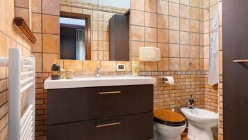 Un bagno con un lavabo, un water, uno specchio e un portasciugamani.