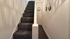 Eine Treppe mit Teppichstufen und einer weißen Wand an der Seite.