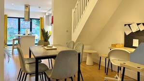 Ein modernes Interieur mit Essbereich, Küche und Treppe.