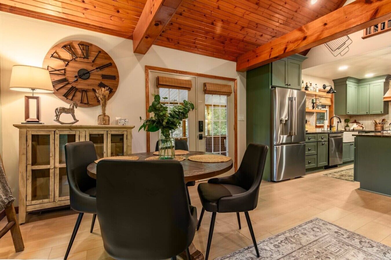 A dining area with a round table, chairs, and a wall clock.