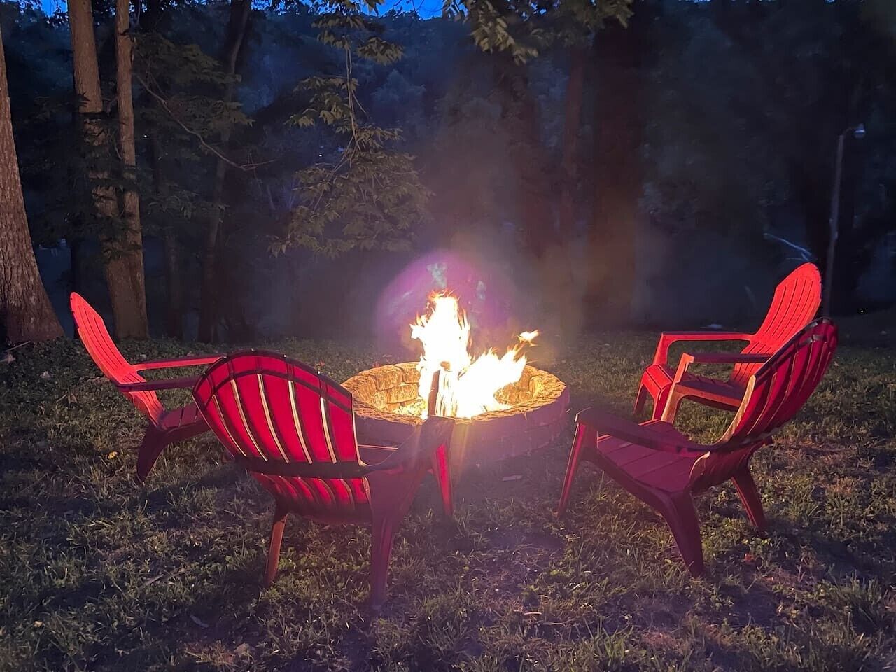 A fire pit with chairs around it.