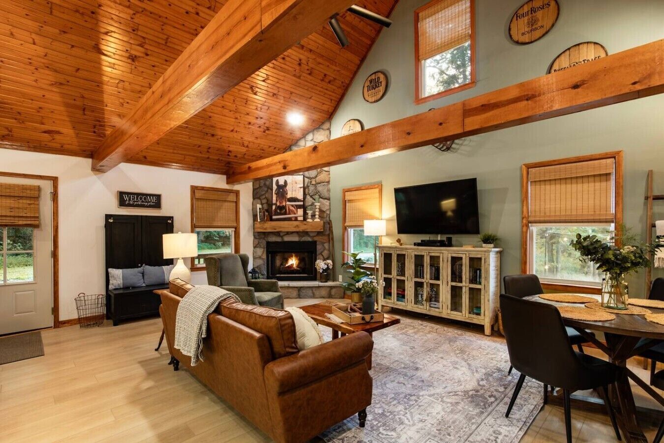 A cozy living room with a fireplace, a television, and a dining area with a table and chairs.
