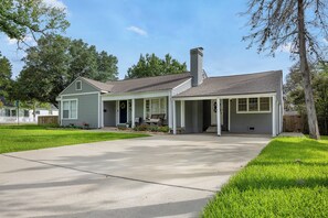 A single-story house with a covered porch, a chimney, and a well-maintained lawn. - Charming Historic District Home  Walking Distance to Kyle Field & TAMU Campus (College Station)