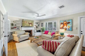 A living room with a fireplace, two sofas, a coffee table, and a television. - Charming Historic District Home  Walking Distance to Kyle Field & TAMU Campus (College Station)