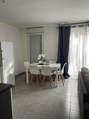 Een moderne keuken met een eettafel, stoelen en een koelkast.