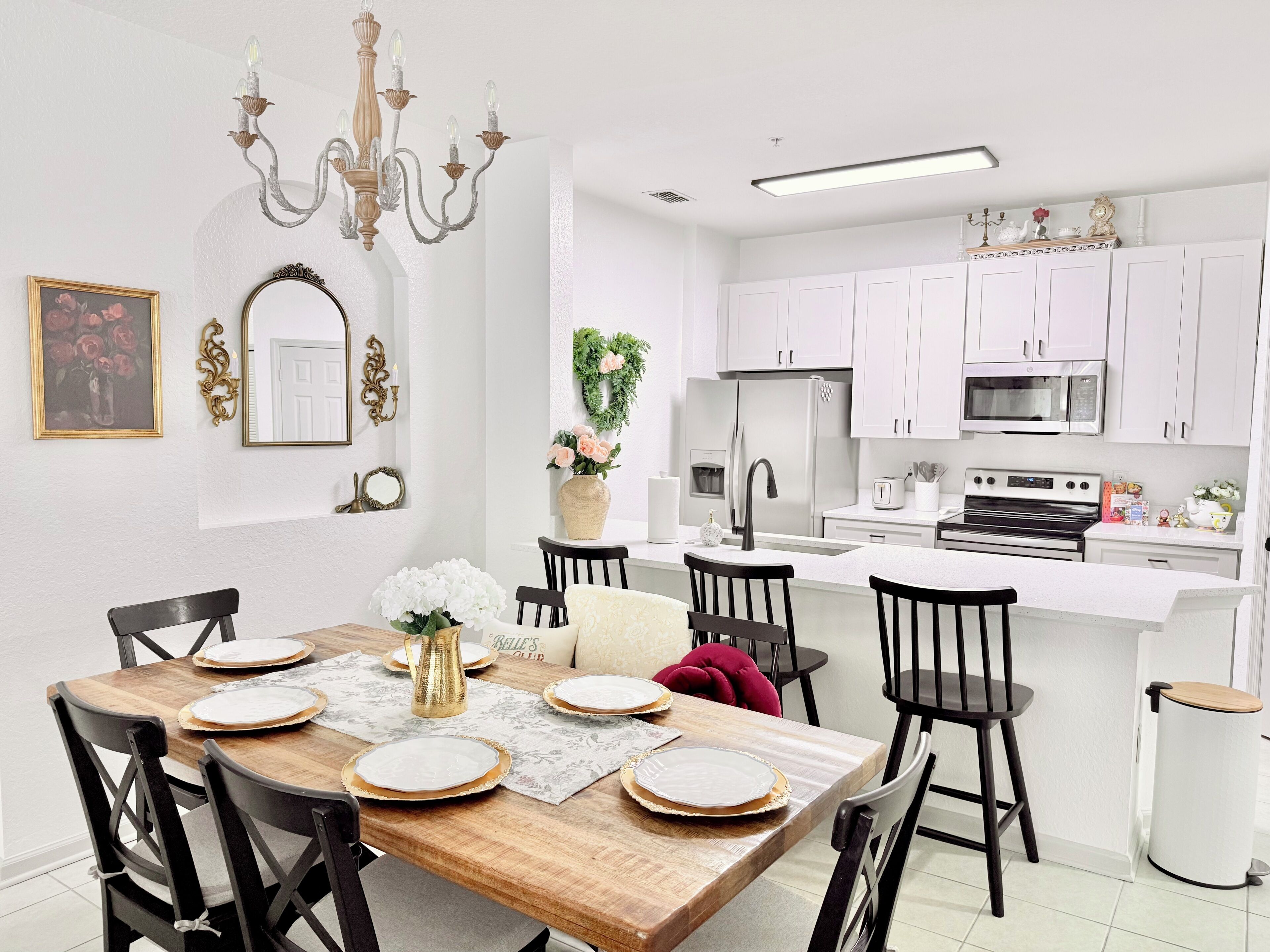 A modern kitchen with white cabinets, a stainless steel refrigerator, and a microwave.