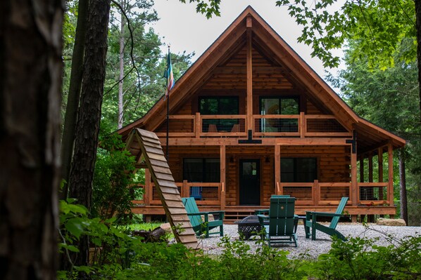 Eine Holzhütte mit Balkon, umgeben von Bäumen.