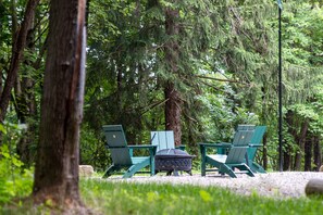 Diverses cadires Adirondack verdes alineades en una zona boscosa amb un camí de grava.
