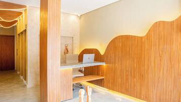 A modern office space with a wooden desk, a laptop, and a chair.
