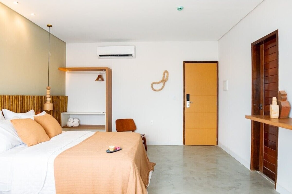 Un dormitorio con cama, mesita de noche, armario y puerta.