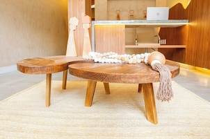 Una mesa de madera redonda con un adorno de macramé y un ordenador portátil.
