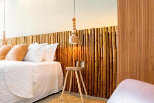 Un dormitorio con cama, mesita de noche y una pared con listones de madera verticales.