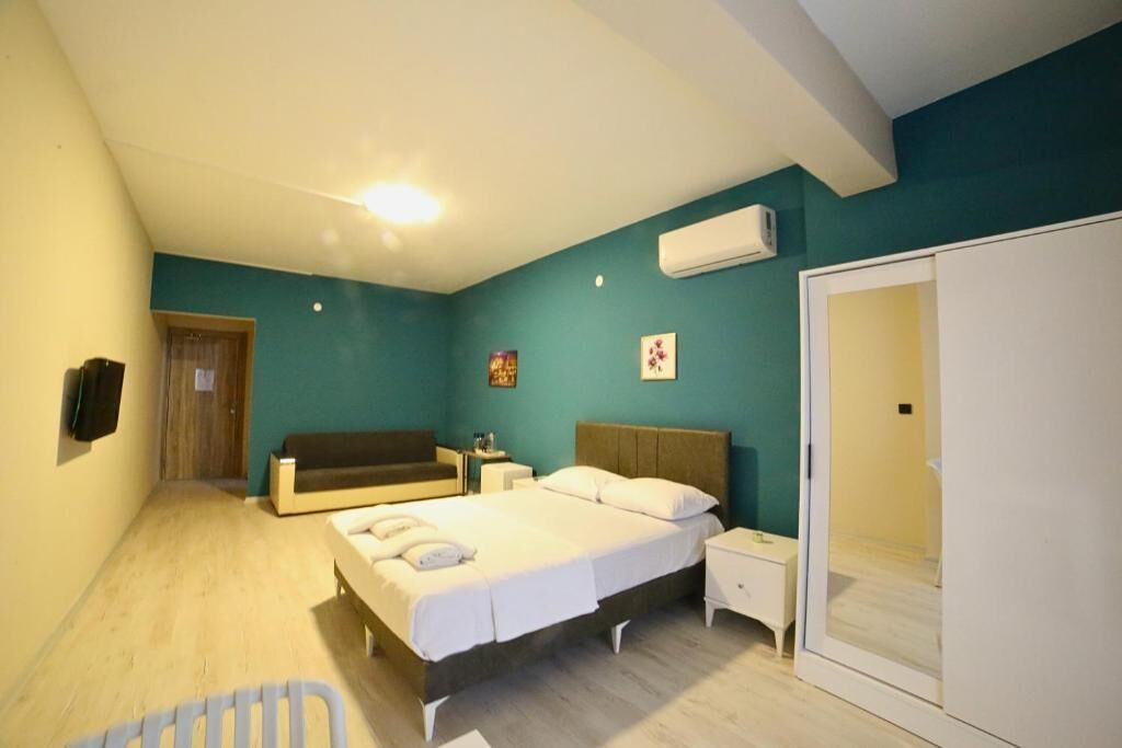 Ein Schlafzimmer mit einem Bett, Nachttischen, einem Kleiderschrank und einer Tür zu einem anderen Raum.