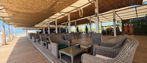 An outdoor seating area with wicker furniture and a wooden deck.