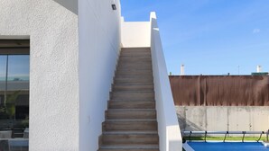 Eine moderne Treppe führt zu einer Dachterrasse mit einem Pool.