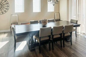 Un espace repas comprenant une longue table, six chaises et un élément décoratif central.