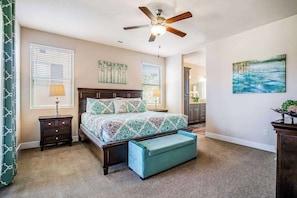 A bedroom with a bed, a ceiling fan, a nightstand, a bench, and a painting on the wall. - Stunning 7BR - Mountainview - Paradise Village (Santa Clara)