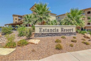 Schild für das Estancia Resort mit freier Sicht auf das Gebäude und die umliegende Bepflanzung.