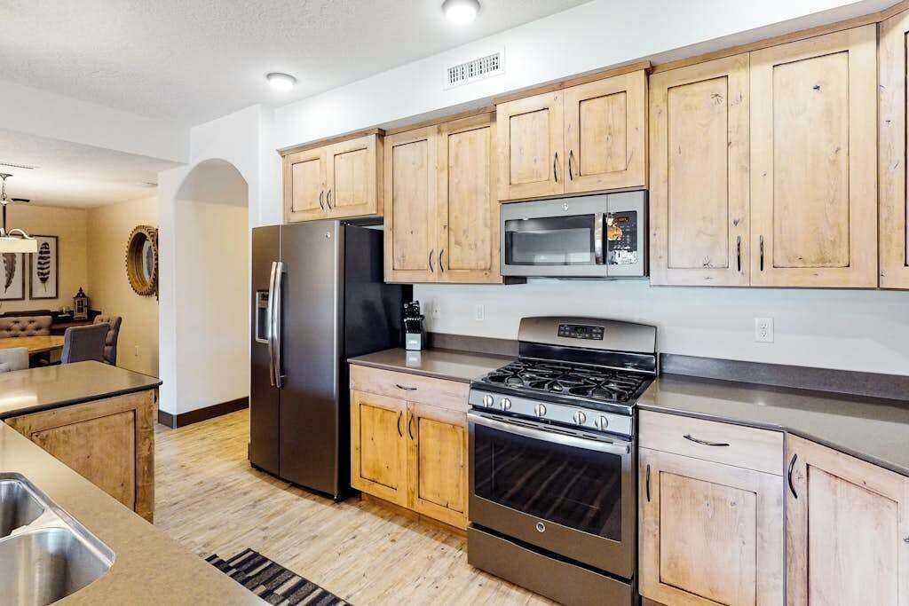 A modern kitchen with wooden cabinets, stainless steel appliances, and a built-in oven.