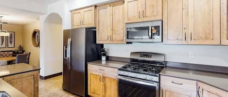 A modern kitchen with wooden cabinets, stainless steel appliances, and a built-in oven.