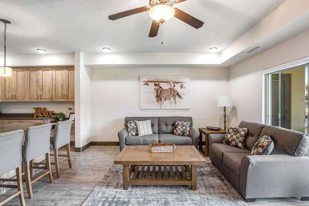 A living room with a sofa, coffee table, and a ceiling fan.