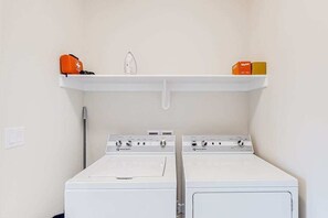 A laundry area with two white washing machines and a shelf above them. - 4BR desert townhouse with game room, bikes, & AC (Washington)