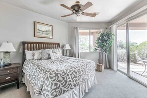 A bedroom with a bed, bedside tables, a ceiling fan, a window with curtains, and a potted plant. - 2BR Zion National Park - Hot tub - Pool (Santa Clara)