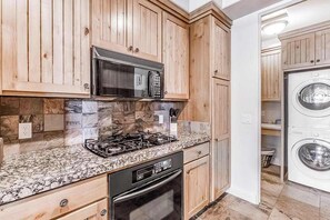 A kitchen with wooden cabinets, a microwave, a gas stove, and a dishwasher. - 2BR Zion National Park - Hot tub - Pool (Santa Clara)