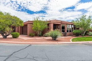 A two-story house with a red exterior, a front porch, and a small patio area. - 2BR Zion National Park - Hot tub - Pool (Santa Clara)