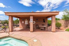A covered outdoor pool area with a hot tub, lounge chairs, and a pool ladder. - 2BR Zion National Park - Hot tub - Pool (Santa Clara)