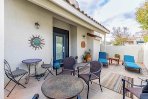 An outdoor patio with a round table, chairs, and lounge seating. - Stylish 1BR Zion National Park - Patio - Pool (St. George)