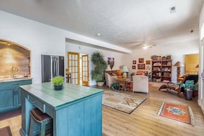 A spacious living area with a kitchen, a dining area, and a seating space. - Stylish 1BR Zion National Park - Patio - Pool (St. George)