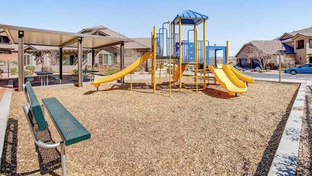 A playground with slides and a climbing structure, surrounded by a covered seating area and a bench. - Spacious townhome with shared pool & hot tub (Washington)