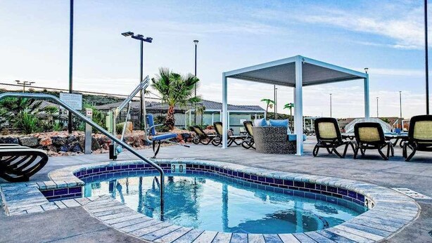 A swimming pool with a sunshade, lounge chairs, and a covered seating area. - Brand New 5BR Zion National Park - Patio (Washington)