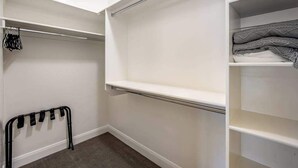 A walk-in closet with open shelves, a hanging rack, and a folded blanket on a shelf. - Brand New 5BR Zion National Park - Patio (Washington)