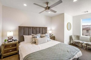 A hotel room with a bed, nightstands, a chair, a ceiling fan, and a window with a view. - Brand New 5BR Zion National Park - Patio (Washington)