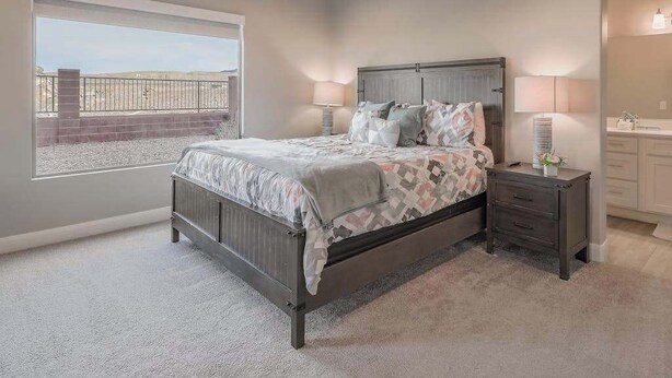 A bedroom with a bed, bedside tables, a window with a view, and a bathroom with a sink and mirror. - 6BR Spacious townhouse with a pool & lazy river (Hurricane)