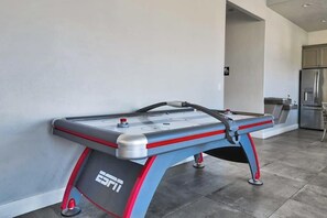 Ein Tischhockey-Spiel in einer modernen Küche mit einem Edelstahl-Kühlschrank und Schränken.