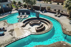 Une piscine de forme circulaire, des chaises longues et un petit espace salon.