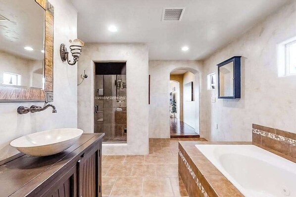 A modern bathroom with a large bathtub, a vanity with a bowl sink, and a mirror. - Spacious 5BR Mountainview Zion National Park (Leeds)