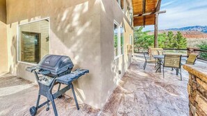 A covered patio with a barbecue grill, outdoor seating, and a view of the surrounding landscape. - Spacious 5BR Mountainview Zion National Park (Leeds)