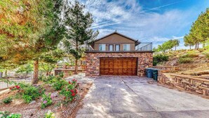 A two-story house with a stone facade, a large garage, and a landscaped driveway. - Spacious 5BR Mountainview Zion National Park (Leeds)