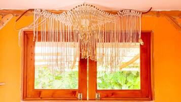 Una ventana con cortina de macramé y un marco de madera.