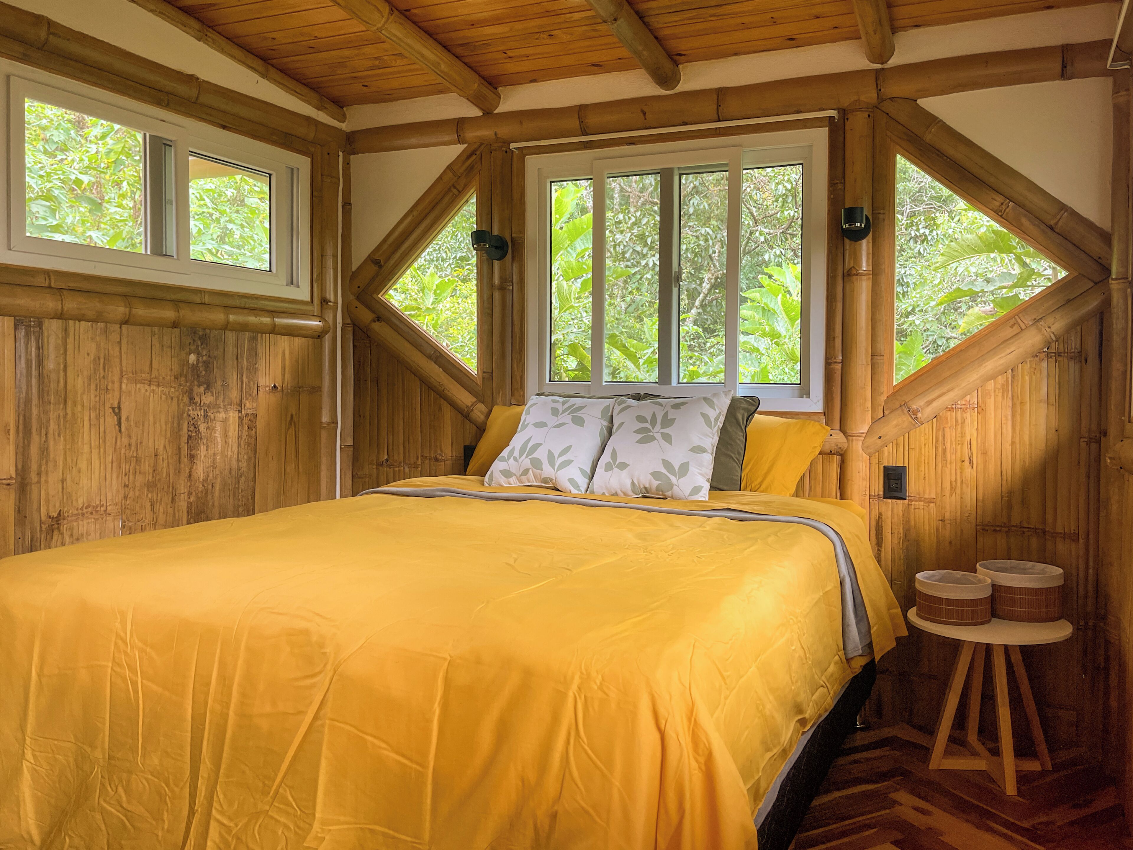 Une pièce avec un lit, une fenêtre et un plafond en bois.