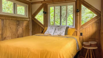 Une pièce avec un lit, une fenêtre et un plafond en bois.