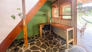 A room with a sloped ceiling, a desk, a chair, and a window. - Granja Tzikin (Santa Cruz La Laguna)