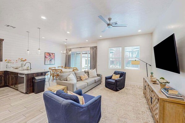 A modern living room with a sofa, armchairs, a coffee table, and a television. - 4BR oasis with pool, hot tub, fire pit, & balcony (Santa Clara)