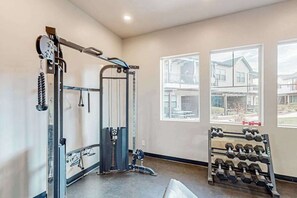 Ein Fitnessraum mit Hantelbank, Langhantelgestell und Kurzhantelständer.
