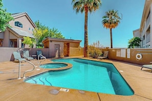 A swimming pool with lounge chairs and a small building, surrounded by palm trees and a clear sky. - 5BR with deck, grill, fireplace, pool, & hot tub (St. George)